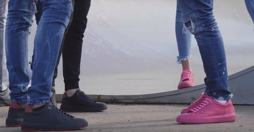 Original GUMSHOE street photograph showing people wearing black and pink sneakers with jeans